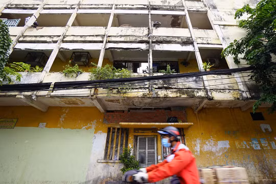 Phần hành lang nối lô A và lô B chung cư Vĩnh Hội đã bị lún sụp và người dân phải che chắn tạm để tránh nguy hiểm. Một phần tường trên trần nhà bị nứt rất dài kéo xuống tới nền gạch. Ảnh: NLĐ.