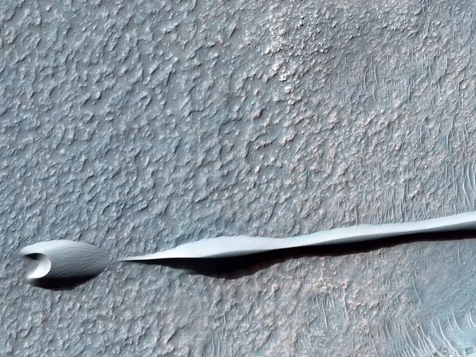 Một đụn cát khổng lồ trông giống như con rắn nằm trong lưu vực tác động Hellas của sao Hỏa. Đụn cát này được hình thành do gió thổi liên tục cùng hướng trong suốt một thời gian dài.