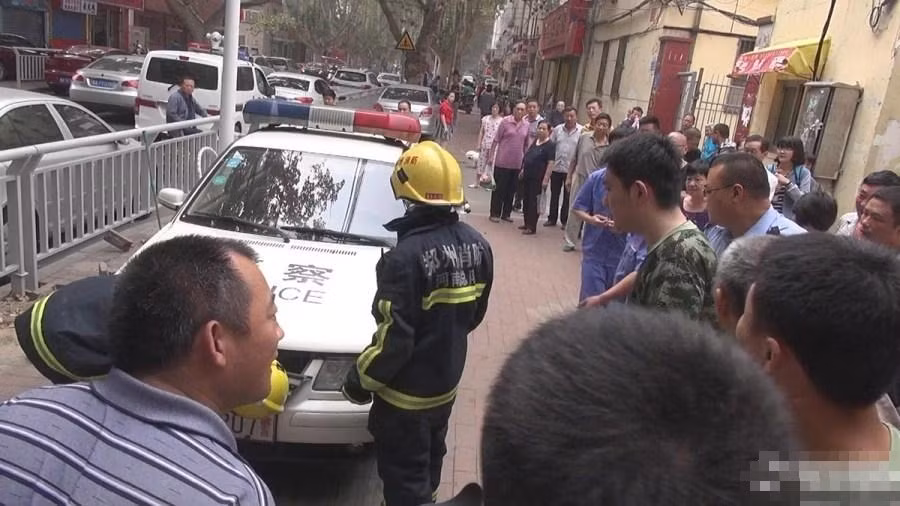 Cảnh sát mặc đồ bảo hộ đang chuẩn bị chế ngự con rắn lạ.