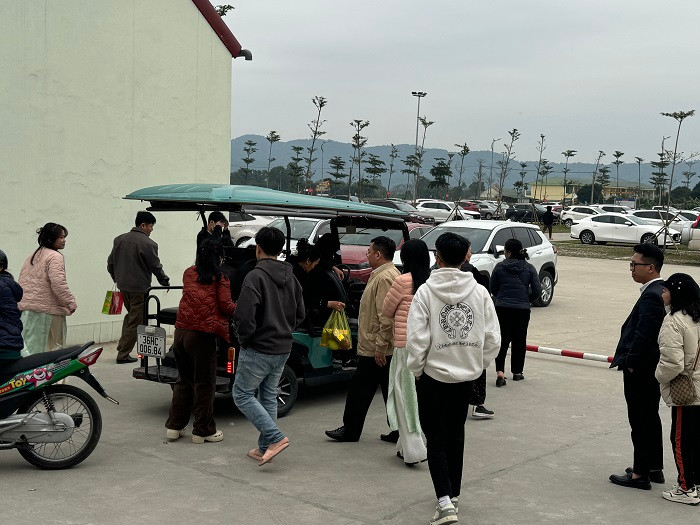 Dịch vụ xe điện hoạt động hết công suất chở miễn phí người dân từ khu vực đền Chợ Củi ra bãi đổ xe.