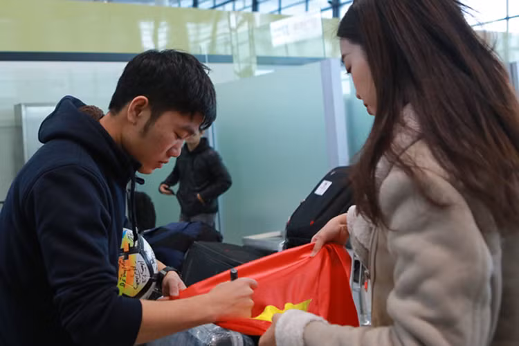 Ngoài Bùi Tiến Dũng, Xuân Trường cũng ký tặng Hoa hậu Đỗ Mỹ Linh ở phòng chờ sân bay. Ảnh: Zing