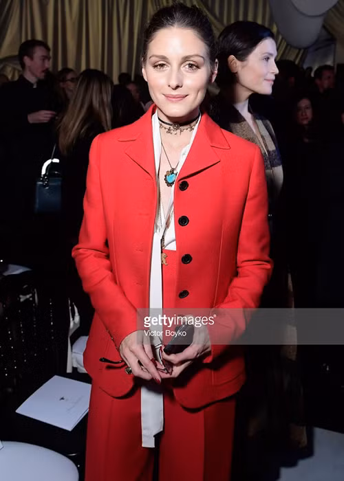 Fashion icon Olivia Palermo diện bộ suit phom dáng nam tính, lấy tông đỏ làm chủ đạo phối cùng áo sơ mi lụa hở ngực và đi kèm những phụ kiện sành điệu như vòng cổ trái tim hay choker cá tính.