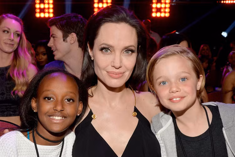 Bé Shiloh tươi rói bên mẹ và chị gái Zahara tại một sự kiện.