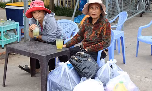 Một số hành khách vào quán nước uống chờ thông xe.