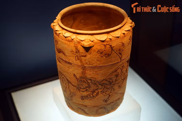 Chiếc thạp cao chừng 40 cm, trên thân có trang trí hình một con hổ đang đuổi theo con ngựa, hàm răng hổ cắn vào đuôi ngựa.