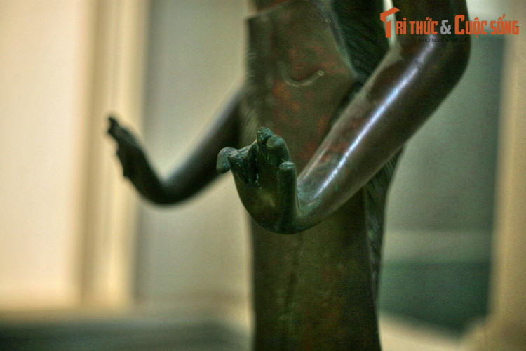 Hai cánh tay của bức tượng được tạo dáng đang đưa về phía trước như đang nâng đỡ hai đồ vật, có thể là một vỏ ốc tù và ở bàn tay trái và đóa sen ở tay phải – những biểu tượng thiêng liêng trong văn hóa Chăm Pa.