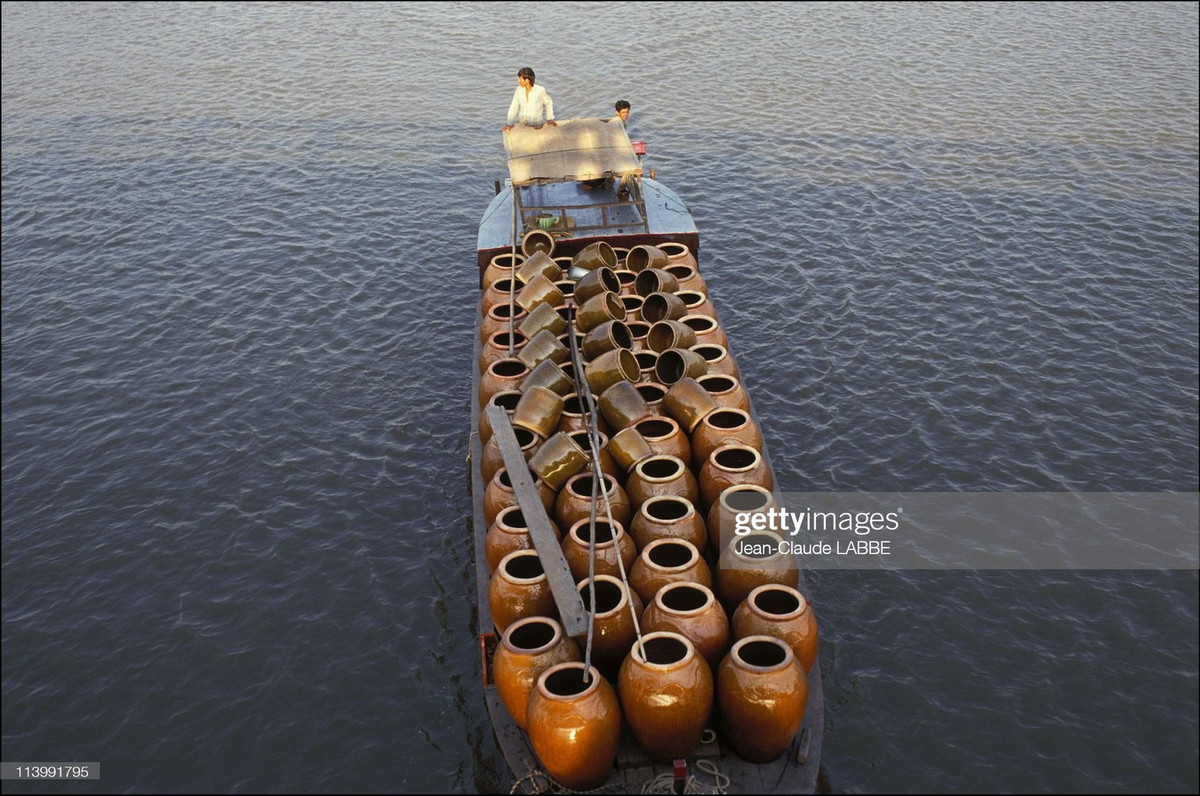 Con thuyền chở đầy vại gốm, thường được dùng để chứa nước mưa ở vùng quê.