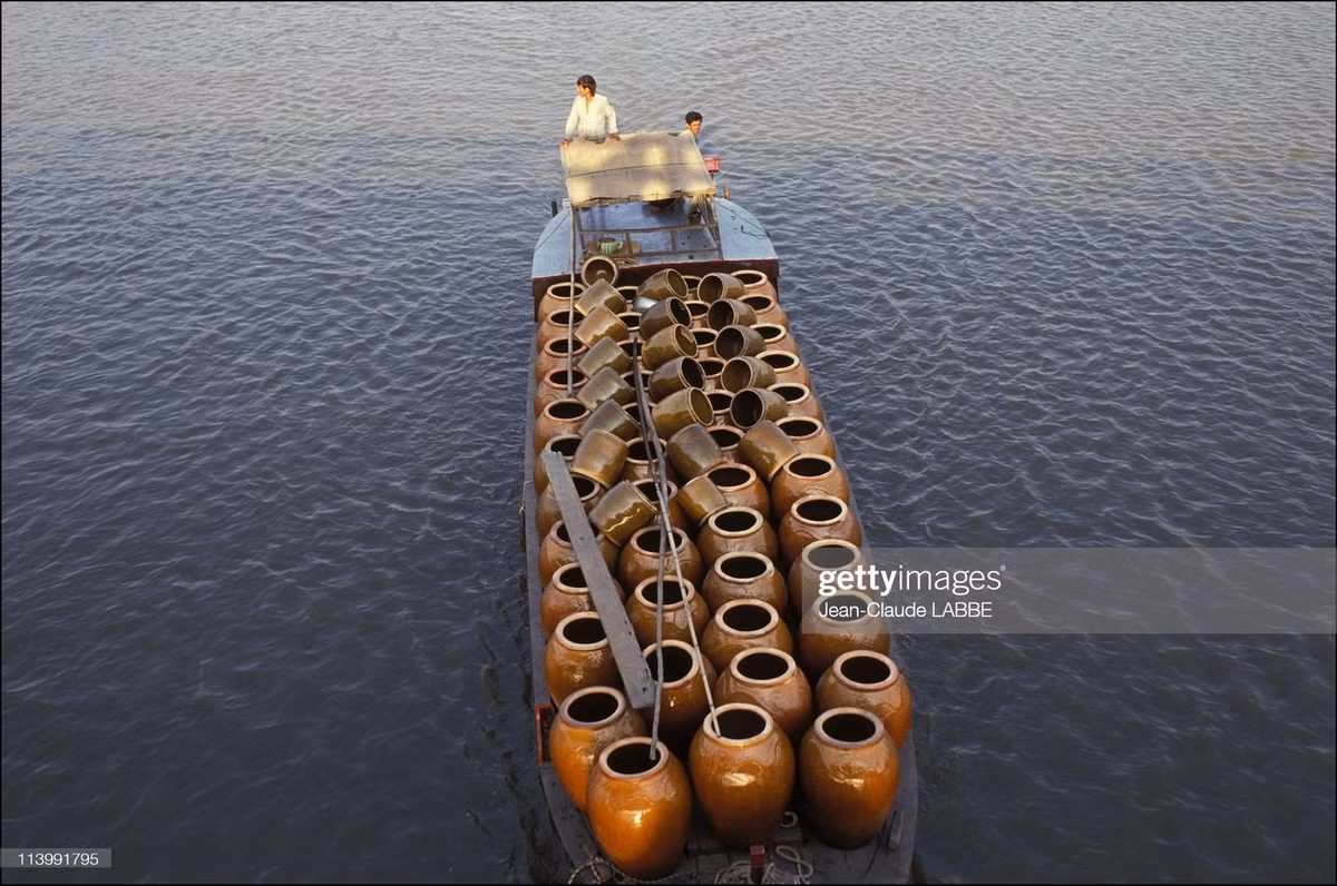 Con thuyền chở đầy vại gốm, thường được dùng để chứa nước mưa ở vùng quê.