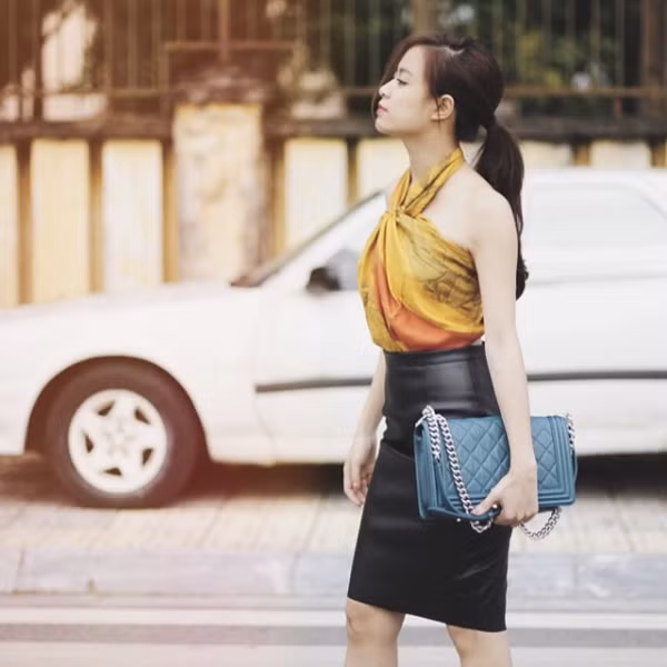 Hoàng Thuỳ Linh thì kín đáo hơn chút khi biến tấu khăn thành áo cổ yếm nhưng không để lộ vòng eo. Ảnh: tiin.