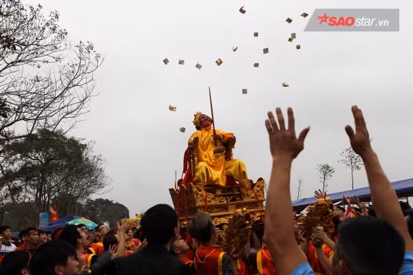Chúa tung tiền lộc ban thưởng cho nhân dân trong ngày lễ hội của làng. Ảnh: Thế Việt