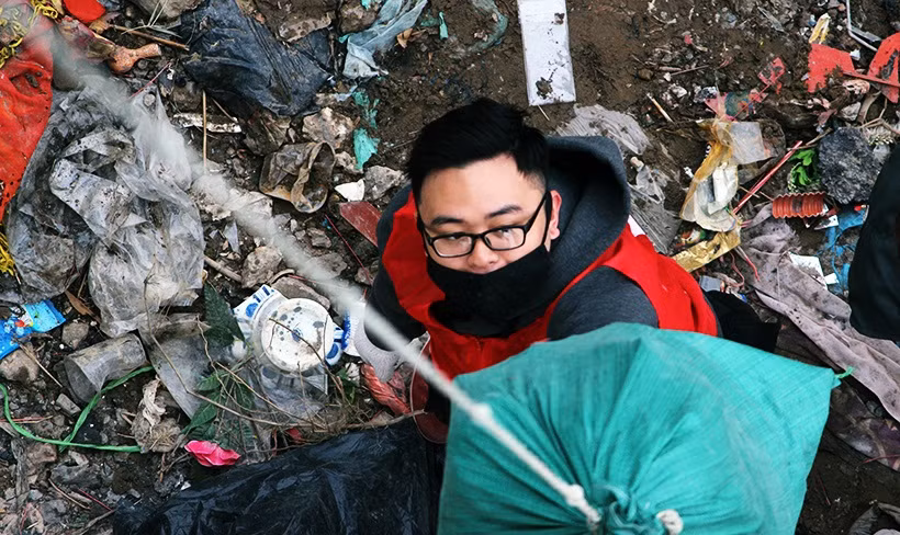 Các tình nguyện viên phải xuống tận dưới chân cầu Long Biên để thu gom rác thải vào một chỗ.