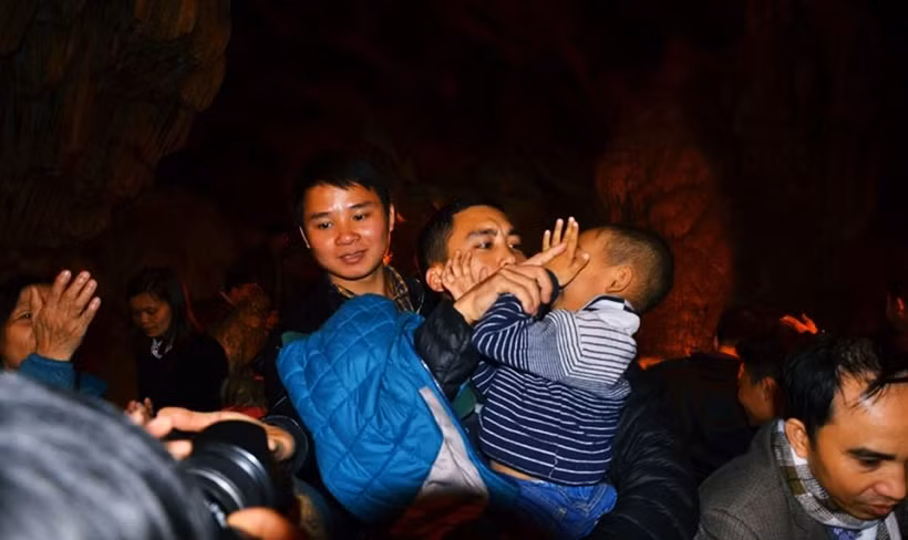 Một em nhỏ được người thân vuốt "nước lộc" lên mặt để lấy may mắn?