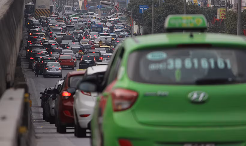 Xe máy phải len lỏi qua dòng ô tô để di chuyển trên đường Nguyễn Xiển hướng đi Phạm Hùng.