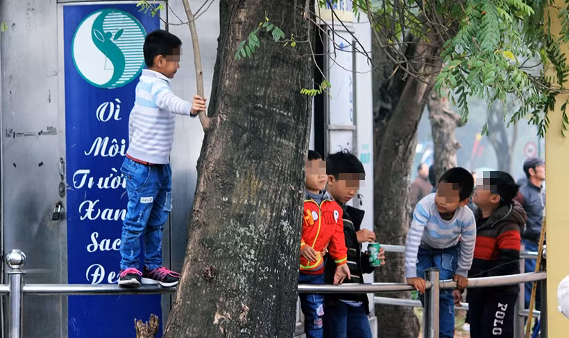Một số bậc phụ huynh lơ là, không chú ý để con em mình thản nhiên vui chơi, leo trèo lên thành chắn khu nhà vệ sinh công cộng rất trơn trượt vì trời mưa phùn, không cẩn thận ngã xuống đất bất cứ lúc nào.