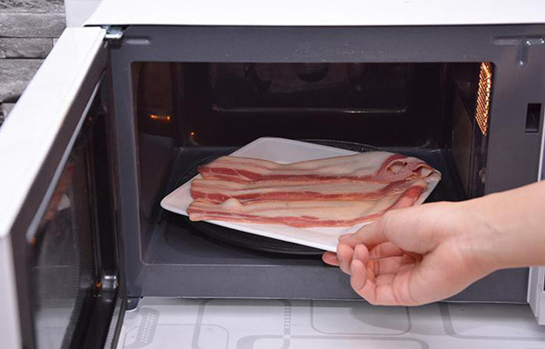 Thịt đông lạnh. Thịt đông lạnh là thực phẩm không nên cho vào lò vi sóng. Nếu bạn dùng lò vi sóng để rã đông thì thịt bên ngoài sẽ được nấu chín nhưng bên trong vẫn còn đông lạnh. Việc này sẽ dẫn tới tình trạng miếng thịt được rã đông không đều, chỗ chín song có chỗ lại còn sống.