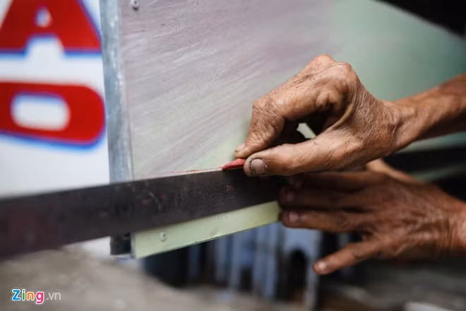 Ông vẫn dùng cách vẽ quảng cáo thủ công như ngày xưa, đó là dùng phấn màu, thước đo để tạo khung chữ. Cao tuổi nhưng ông vẫn chắc tay cho từng đường kẻ.