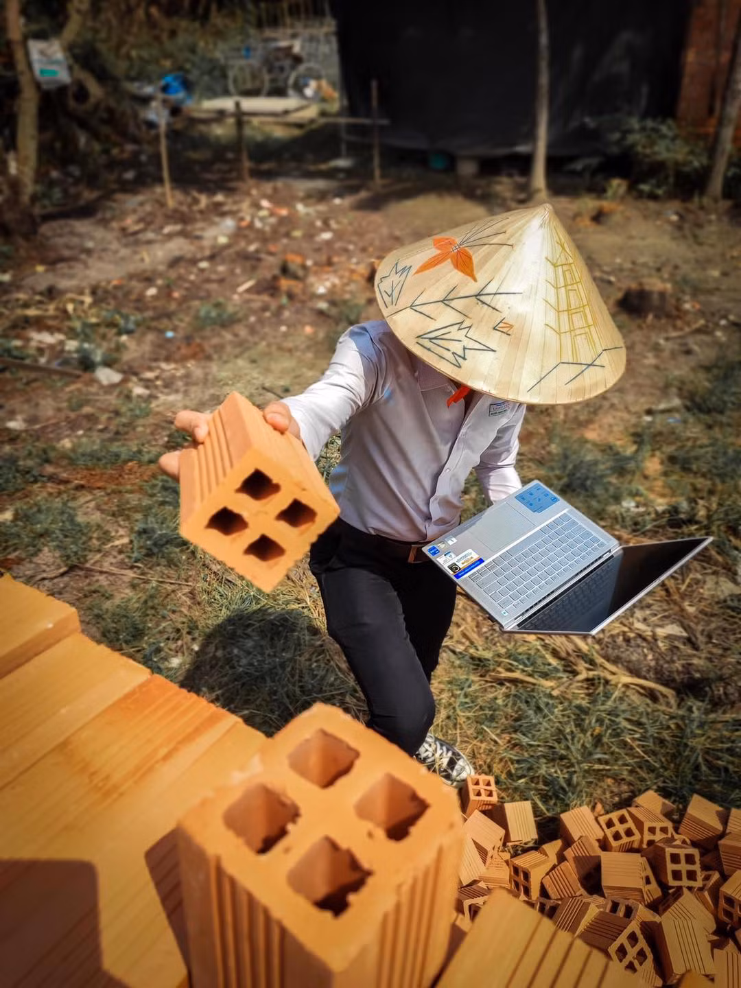 Nhà đang xây dựng dở nhưng cậu không quên phụ giúp bố mẹ, một tay xếp gạch, một tay cầm máy tính học online.