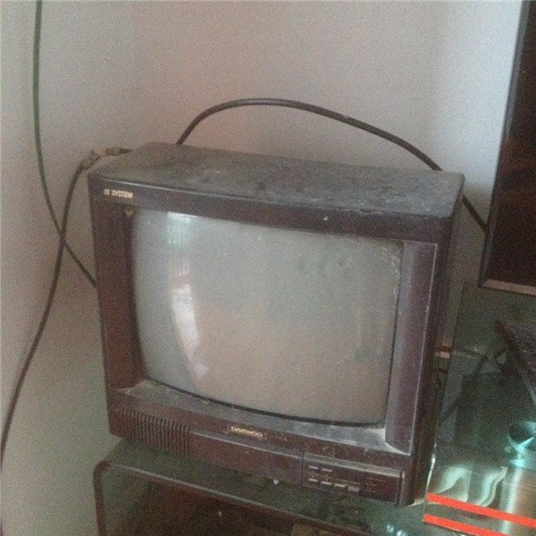 Chiếc ti vi bám đầy bụi, nhỏ nhỏ, có màn hình lồi, khác hẳn với những thiết kế siêu mỏng hiện đại bây giờ.