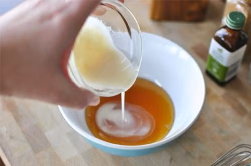 Bỏ 2 thìa đường nâu vào hỗn hợp trên rồi khuấy đều tay đến khi thu được hỗn hợp dạng sền sệt. Đổ hỗn hợp vào lọ thủy tinh, đậy kín nắp và bảo quản trong ngăn mát tủ lạnh.