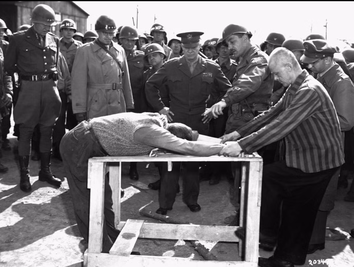 Tướng Dwight D. Eisenhower quan sát cách tù nhân đã bị tra tấn thế nào trong trại tập trung của Đức. Tướng Bradley và Patton đứng bên phải.
