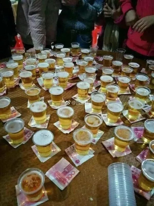 Còn đây là uống bia đổi lì xì. Tất cả mọi người đều vây quanh chiếc bàn với hy vọng nhận được tiền lì xì trong năm mới.