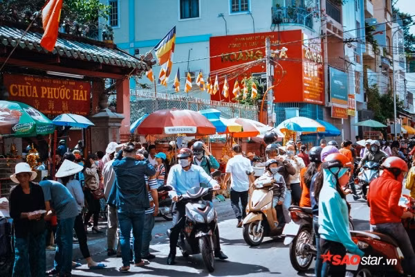 Theo ghi nhận vào lúc 14h, đã có hơn hàng nghìn người đổ về tuyến đường Mai Thị Lưu, chen chân nhau khấn vái tại chùa Ngọc Hoàng. Dù được nhắc nhở liên tục về việc chỉ nên thắp một nén hương, hạn chế đốt vàng mã và đề phòng trộm cắp… nhưng nhiều sự cố vẫn xảy ra. Thời tiết 34 độ C khiến vô số người dân vật vã mồ hôi, mệt mỏi khấn vái. Ngoài ra, vì chờ đợi khá lâu không thể vào được bên trong chùa nên nhiều trường hợp cũng đành khấn vái và thắp hương ngoài điện. Ảnh: Con đường Mai Thị Lựu đã được ngăn lưu thông ngay từ sáng sớm để phục vụ cho người dân đổ về chùa khấn vái.