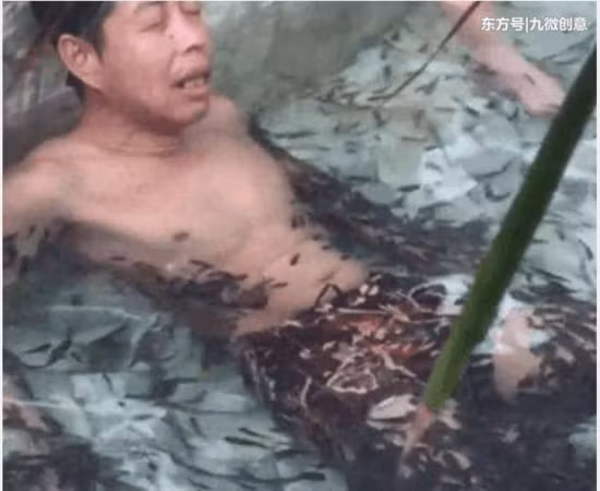 Người đàn ông ngâm cả người xuống bể cá.