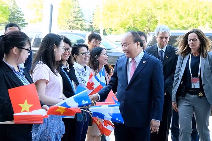 Tiếp đó, sáng 8/6, theo giờ Canada, tức tối 8/6 (theo giờ Việt Nam), Thủ tướng Nguyễn Xuân Phúc tham dự sự kiện mở đầu chương trình dự Hội nghị Thượng đỉnh G7 mở rộng và thăm Canada, đó là chuyến thăm Đại học Quốc tế Laval tại Bang Québec – trường đại học lâu đời nhất ở Canada và khu vực Bắc Mỹ. Trong ảnh: Các sinh viên Việt Nam chào đón Thủ tướng Nguyễn Xuân Phúc.