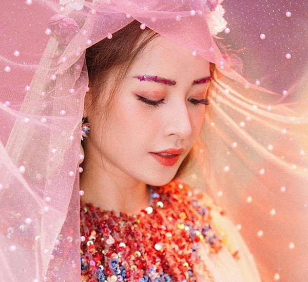 Sở hữu gương mặt với đường nét thanh tú, đôi mắt to tròn, Chi Pu cho phép chuyên gia trang điểm tha hồ thể hiện sự sáng tạo. Cô nàng từng thử nghiệm hàng loạt cách makeup độc đáo, mỗi MV lăng xê một kiểu làm đẹp riêng. Trong MV Cho ta gần hơn, Chi Pu được đính kim sa lấp lánh lên lông mày, tông xuyệt tông với chiếc váy đang mặc.