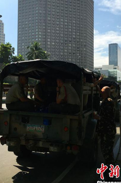 Một xe chở các sĩ quan cảnh sát đang di chuyển trên đường phố Manila.