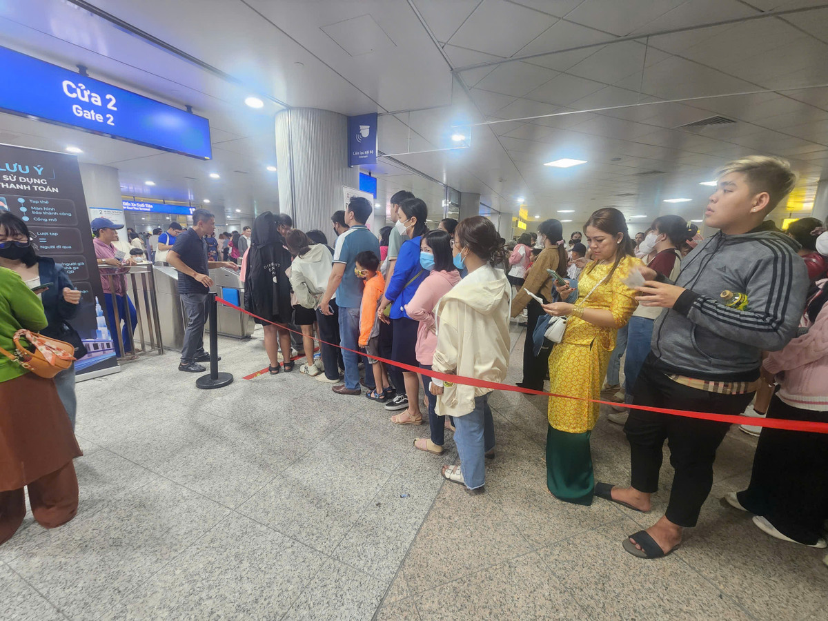 Sau khi mua được vé, người dân lại tiếp tục chờ đến lượt qua cổng để vào khu vực đi Metro. 