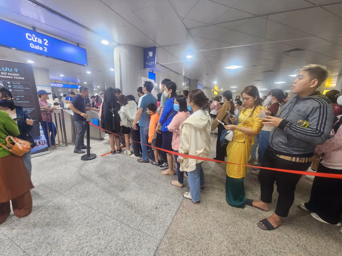 Sau khi mua được vé, người dân lại tiếp tục chờ đến lượt qua cổng để vào khu vực đi Metro. 