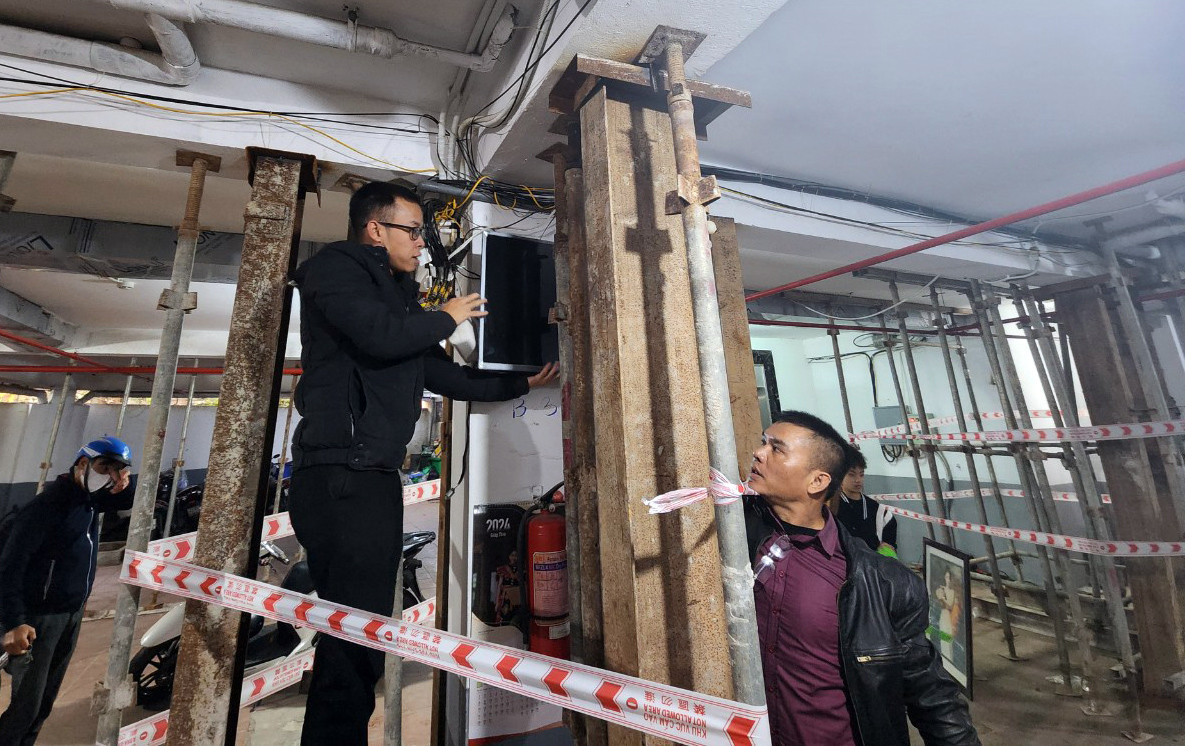 Nhân viên tháo dỡ các thiết bị trong tầng để xe của chung cư mini để chuẩn bị gia cố phần xuống cấp của tòa nhà.