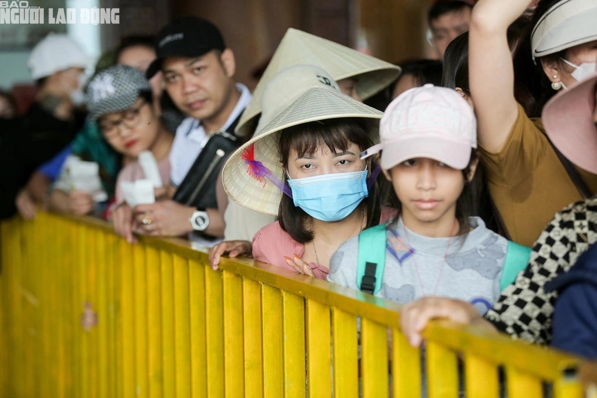 Khách du lịch xếp hàng qua điểm kiểm soát vé để xuống tàu. Để tránh ùn ứ, ban quản lý tổ chức phân làn từ nhà chờ bên ngoài vào phía trong.