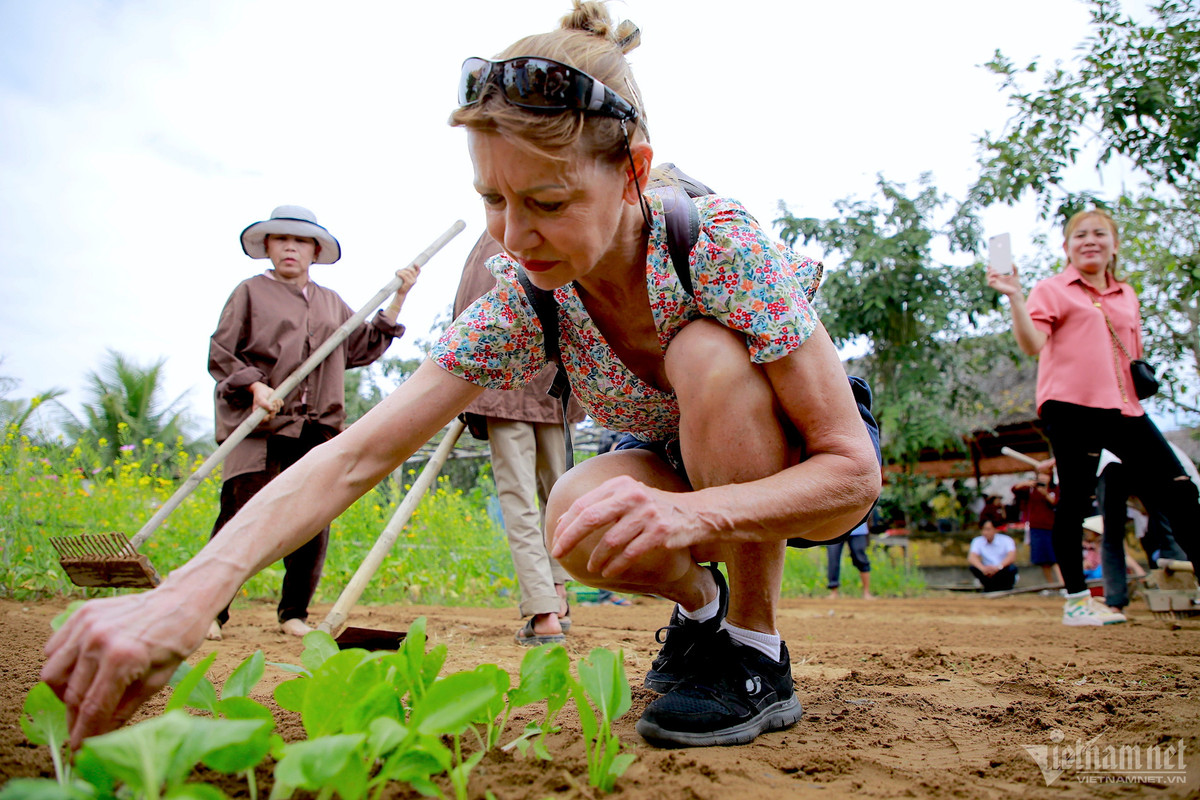 Ngay cạnh, vợ của ông cũng đang được nông dân hướng dẫn các bước trồng rau. Bà thích thú khi được trồng những luống rau đầu tiên tại hoạt động lần này.