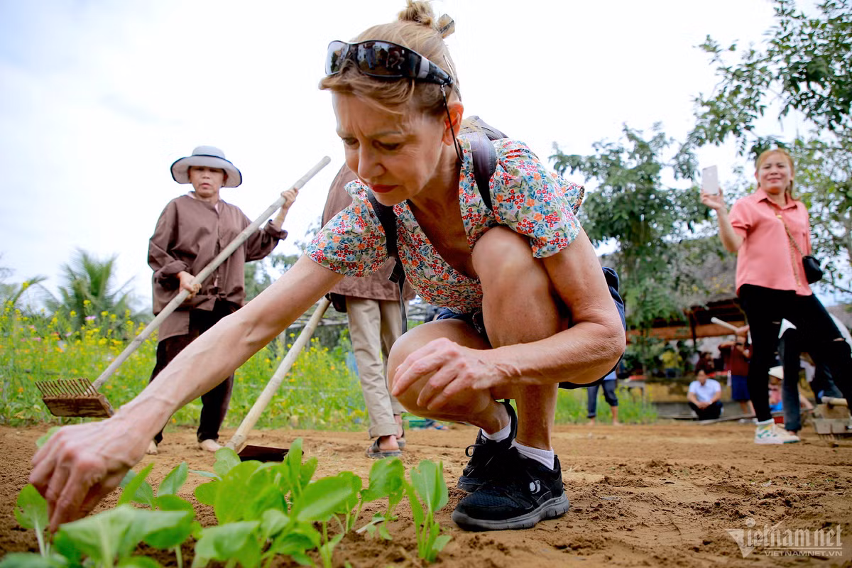 Ngay cạnh, vợ của ông cũng đang được nông dân hướng dẫn các bước trồng rau. Bà thích thú khi được trồng những luống rau đầu tiên tại hoạt động lần này.