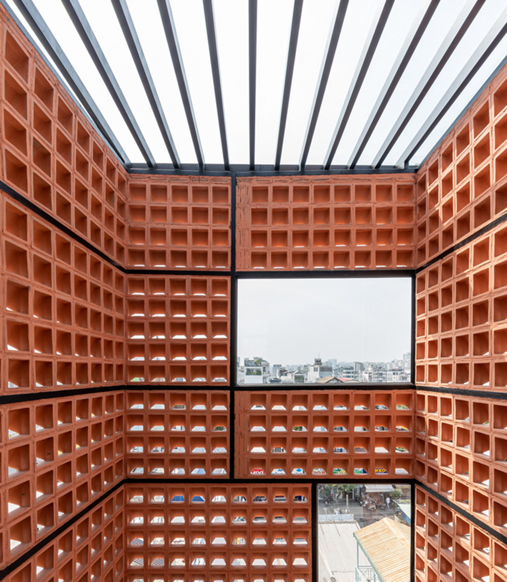 Cầu thang có một tấm bình phong bằng gạch nung, đảm bảo thông gió tự nhiên và tránh bị mưa. Các tấm kính được thiết kế khéo kéo giúp cho không gian sống luôn có ánh sáng tự nhiên và tạo ra những cửa sổ nhỏ khi nhìn lên bầu trời.