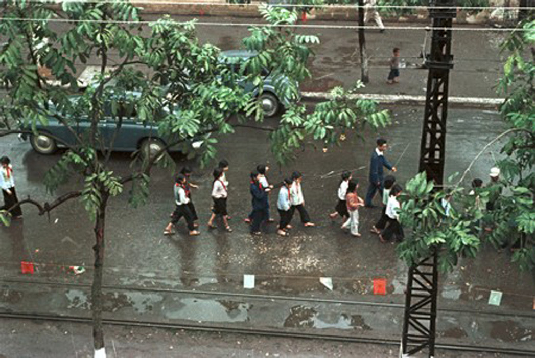 Một nhóm học sinh xếp hàng đi trên đường.