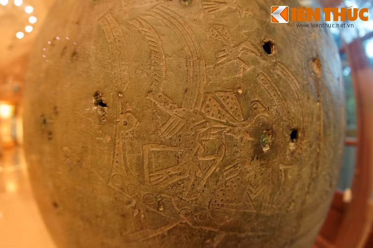 Đáng chú ý nhất là tám chiếc thuyền, thể hiện thành bốn cặp thuyền dính với nhau bởi hình hai con cá sấu đấu chân đối nhau. Trên thuyền có những tốp người cầm vũ khí. Trên bầu trời có chim bay, phía dưới là cá và các loài chim, thú ăn bắt cá.