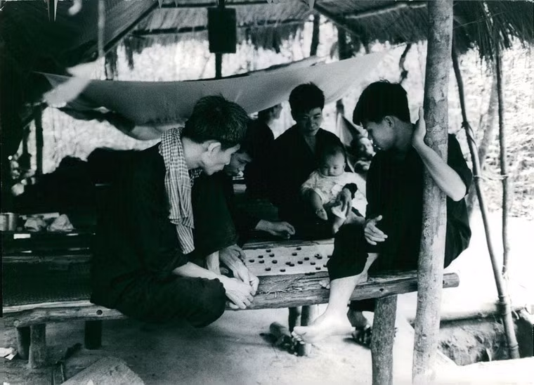 Cảnh sinh hoạt đời thường của các chiến sĩ Giải phóng tại căn cứ Củ Chi, 1967. Cạnh chiếc lều lá có lối dẫn xuống địa đạo. Hỉnh ảnh nằm trong kho dữ liệu ảnh của các phóng viên quốc tế thời chiến tranh Việt Nam.