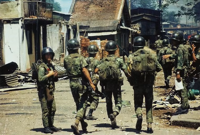 Binh lính Sài Gòn tuần tra di chuyển trên con đường ngổn ngang gạch đá.