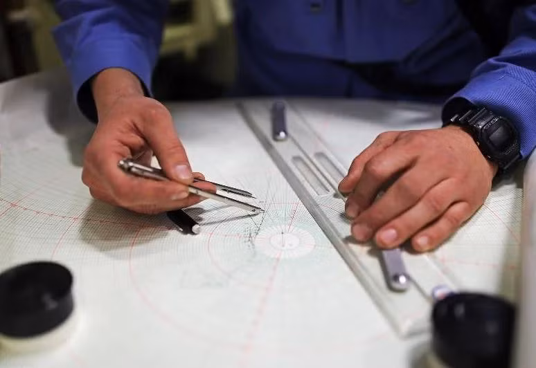 Sĩ quan dẫn đường trên tàu ngầm Kilo đang sử dụng bản đồ để vẽ hải trình di chuyển cho tàu. Nguồn ảnh: Expo.