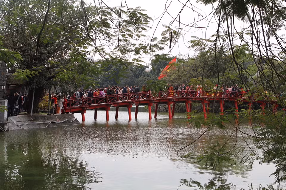 Cầu Thê Húc nổi bật giữa Hồ Gươm với sắc sơn đỏ. Vào mùng 2 Tết Canh Tý, rất nhiều người dân đến đây vui chơi, chụp ảnh.