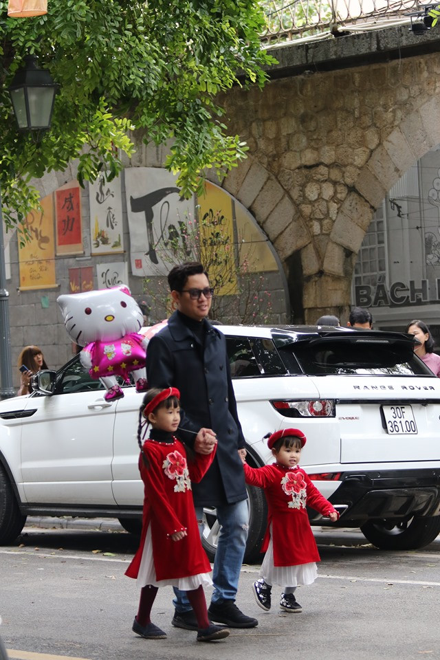 Hai bé gái đi dạo chơi ngày Tết cùng với gia đình.