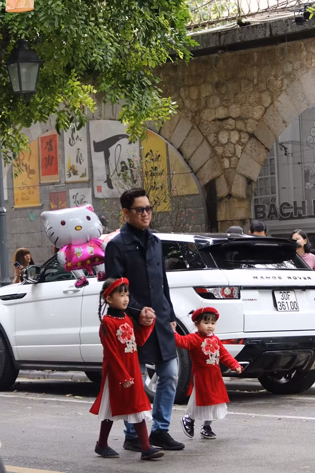 Hai bé gái đi dạo chơi ngày Tết cùng với gia đình.
