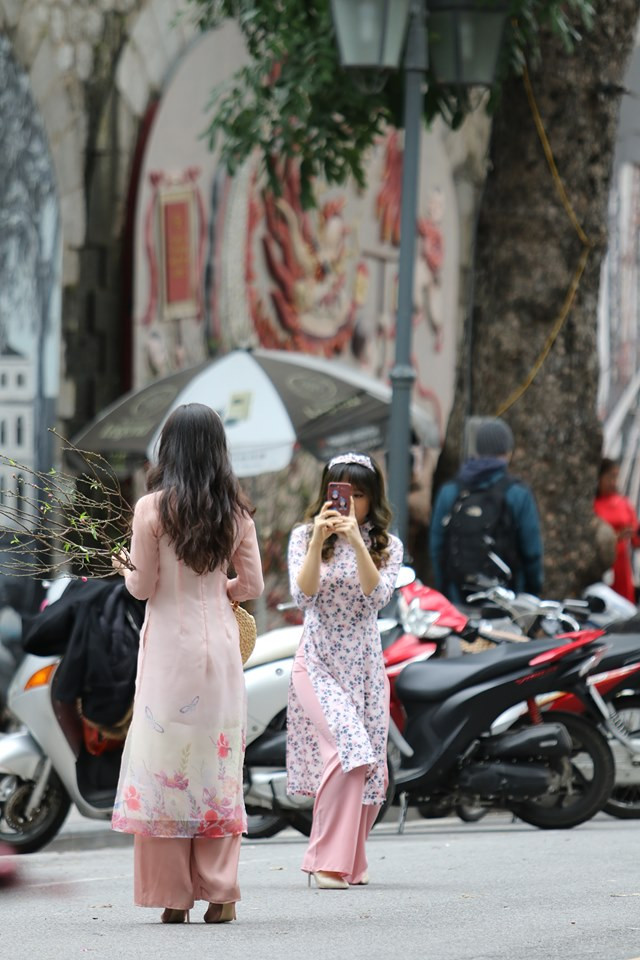 Hai thiếu nữ trong tà áo dài thướt tha trên phố bích họa Phùng Hưng.