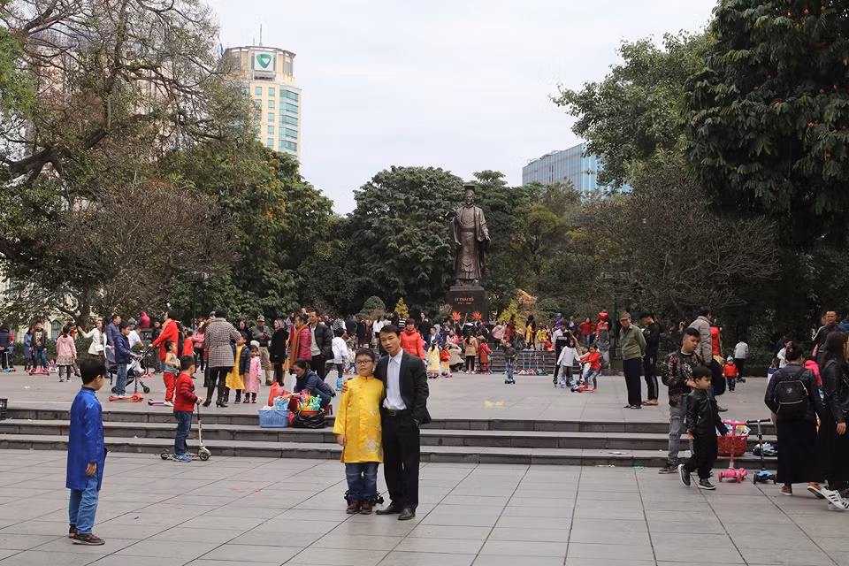 Nhiều em nhỏ trong trang phục áo dài truyền thống đi du xuân, ngắm cảnh cùng gia đình và chụp ảnh tại tượng đài Lenin.