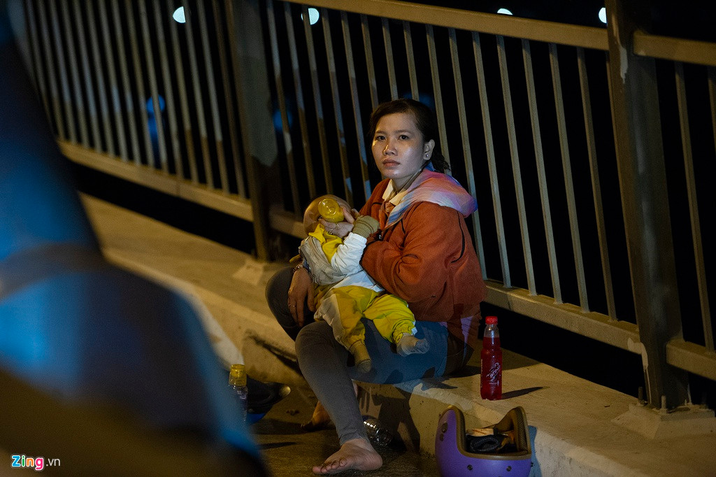 Chị Oanh hiện làm việc tại TP.HCM. Chiều 28 Tết, chị cùng chồng đưa con nhỏ về Hậu Giang. Thay vì đi xe khách, gia đình chị chọn xe gắn máy làm phương tiện. Sau nhiều giờ di chuyển, đến cầu Mỹ Thuận, chị Oanh dừng chân nghỉ ngơi và tranh thủ cho con bú.