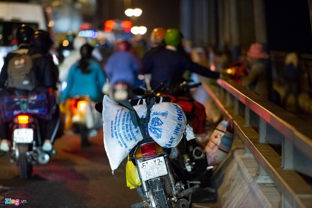 Nhiều người dựng xe máy sát lề phải cầu, sau đó trèo sang khu vực phần đường dành cho người đi bộ để nghỉ ngơi. Cao điểm có khi lến đến hàng trăm chiếc xe dựng ở đây.