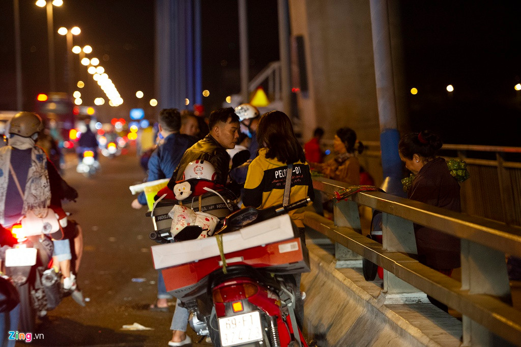 Những chiếc xe máy chở đồ dùng cồng kềnh dừng lại trên cầu khiến lối di chuyển của dòng xe cộ trở nên chật hẹp hơn.